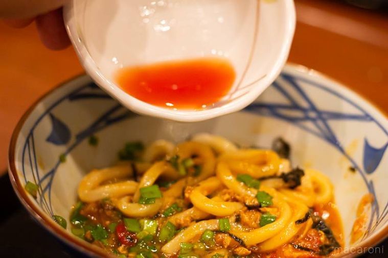 丸亀製麺ガツンとニンニク肉辛まぜうどんひと口ごはん、トマト酢つきにトマト酢をかけている