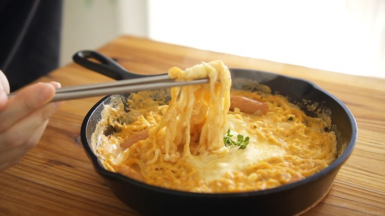 スキレットに入ったロゼ辛ラーメンを箸で食べる
