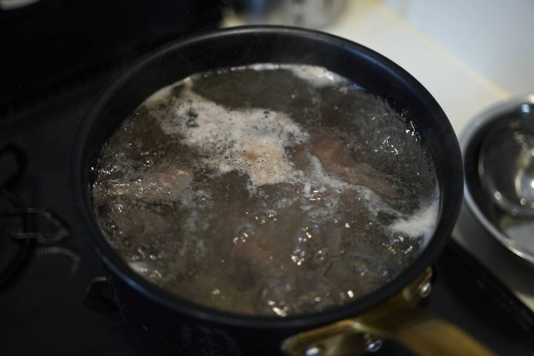 アクが浮いた牛すじを煮込んでいる鍋