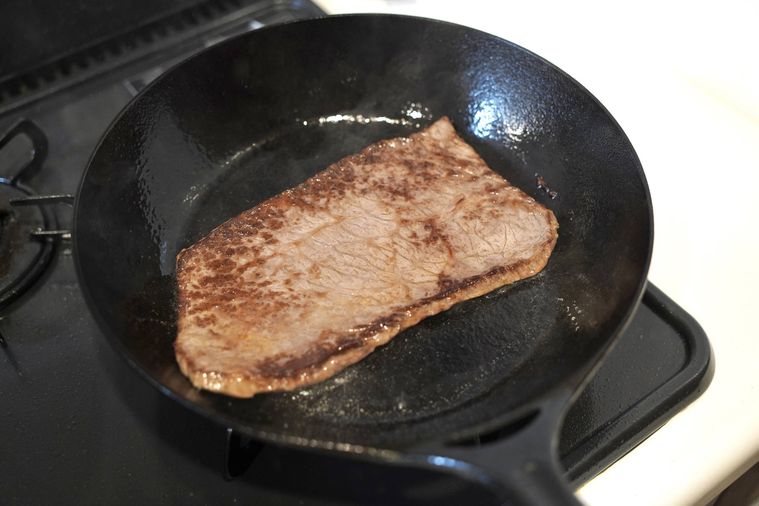 フライパンの上で焼き目がついたステーキ肉