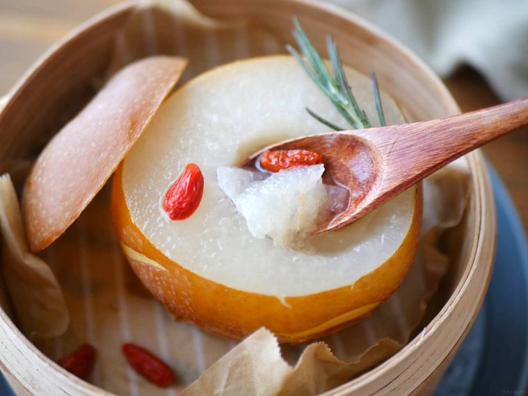 蒸し梨をスプーンですくって食べる様子