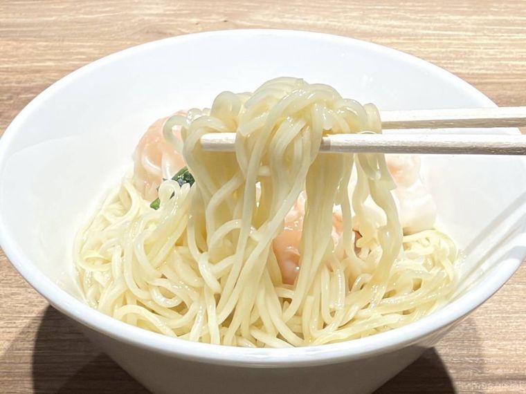 香港風 ぷりぷり海老ワンタン麺の麺を箸で持ち上げた様子