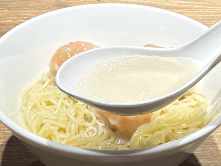 香港風 ぷりぷり海老ワンタン麺のスープをレンゲですくった様子