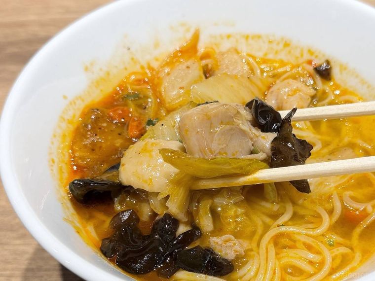 四川風 辛辛やみつき麻辣麺の鶏肉を箸で持ち上げた様子
