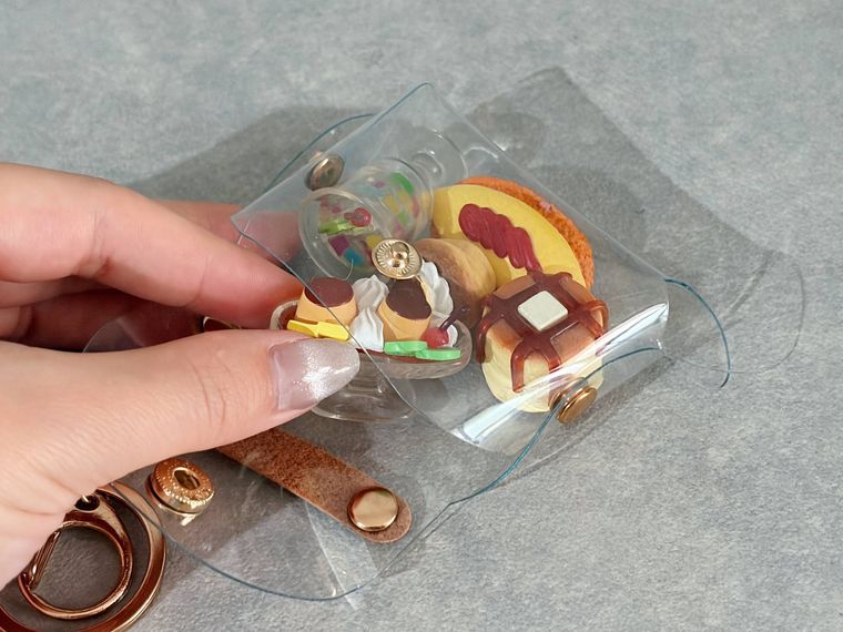 セリアのPVCバッグポーチに食べ物のフィギュアを入れる様子