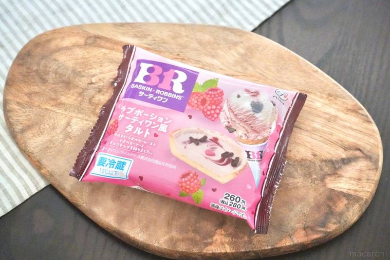 木のカッティングボードにのったアイスクリームのラブポーションサーティワンをイメージしたコンビニスイーツのピンク色のパッケ