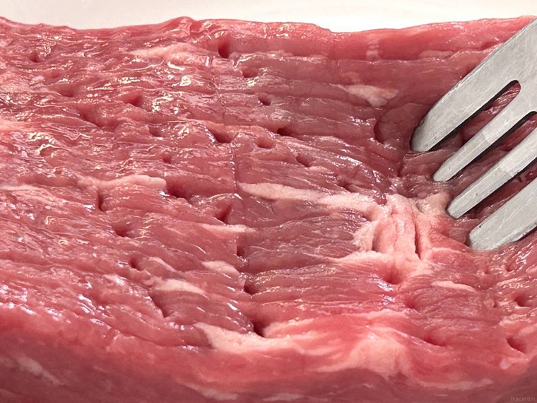 牛もも肉全体にフォークで穴を開けているところ