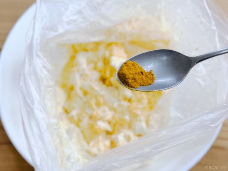 卵サラダにカレー粉を加えようとしている様子