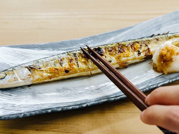 焼きさんまの身を箸で押さえている様子