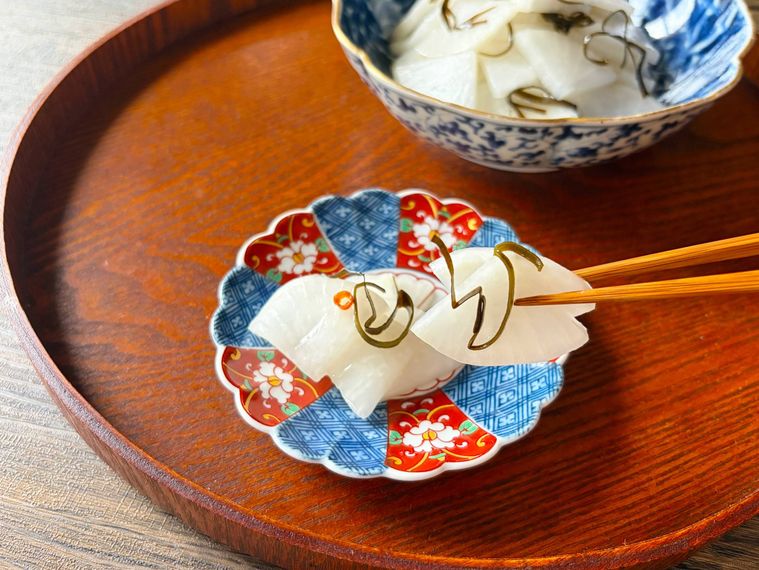 小皿に取り分けた大根の甘酢漬けを箸あげする様子