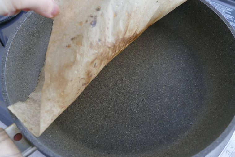 さんまを焼いたあとのクッキングシートを取り出す様子