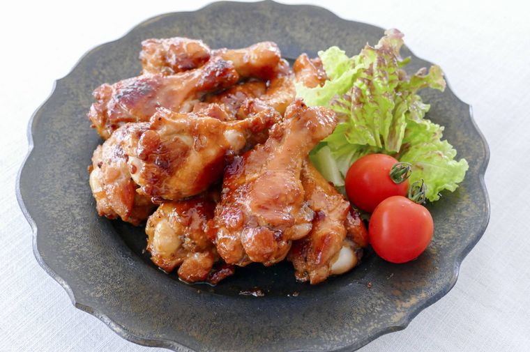 和風ローストチキンとレタス、ミニトマトを盛り付けた黒い大皿