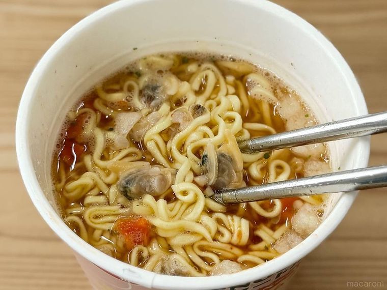 スヌーピー マンハッタンクラムチャウダー味ヌードルを箸ですくっている様子