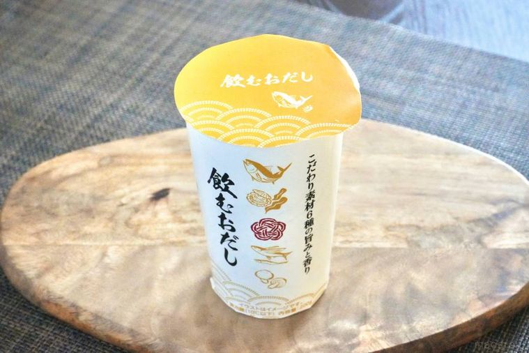 木のカッティングボードにのった飲むおだしのカップ飲料