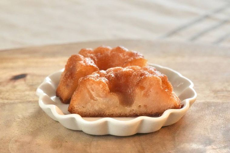 木のカッティングボードと白い小皿にのったコンビニのバター餅の断面