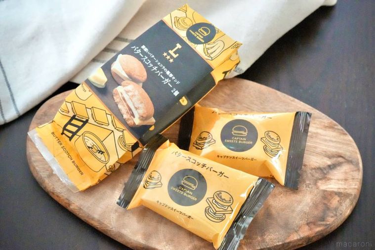 木のカッティングボードにのった黄色と黒色のパッケージのバタースコッチバーガー