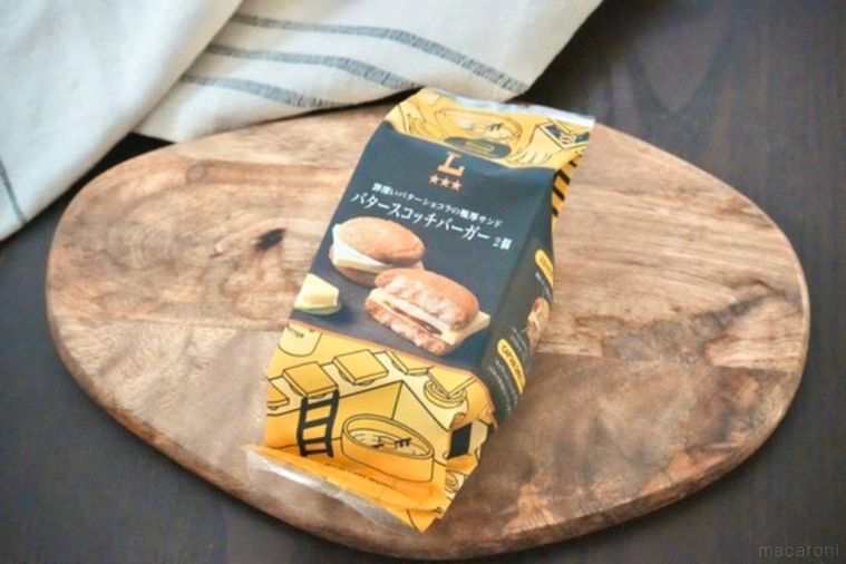 木のカッティングボードにのった黄色と黒色のパッケージのバタースコッチバーガー