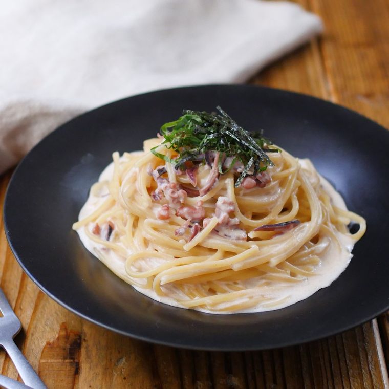 黒い丸皿に盛られた、 塩辛のクリームパスタ