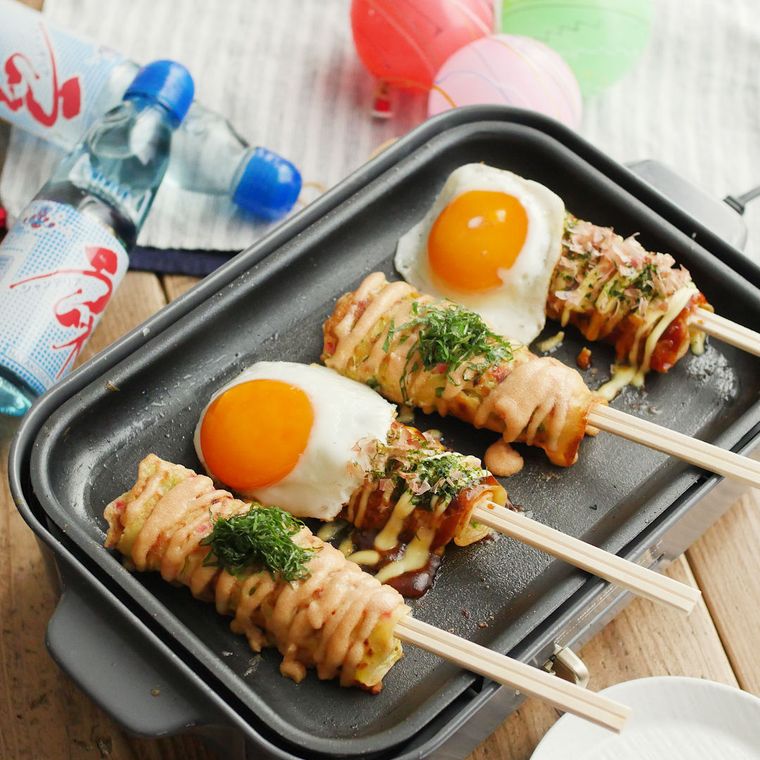ホットプレートにのせた4本のはしまきとラムネの瓶