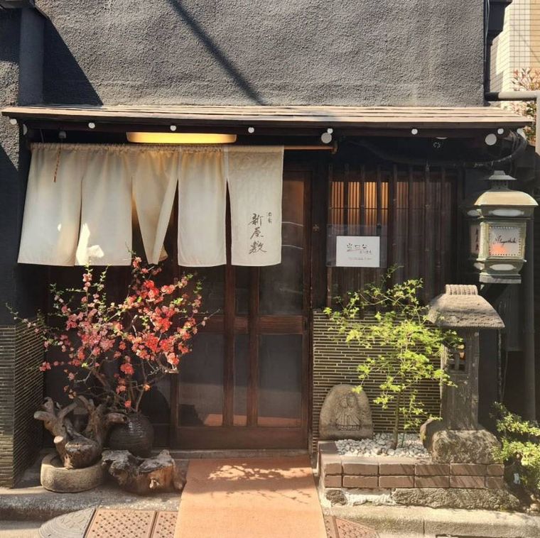 白いのれんがかけられた和風建築の酒肴 新屋敷の外観