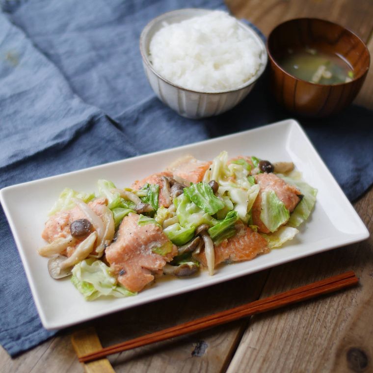 白い皿に盛りつけられた鮭のちゃんちゃん焼きにごはんとみそ汁が添えられている