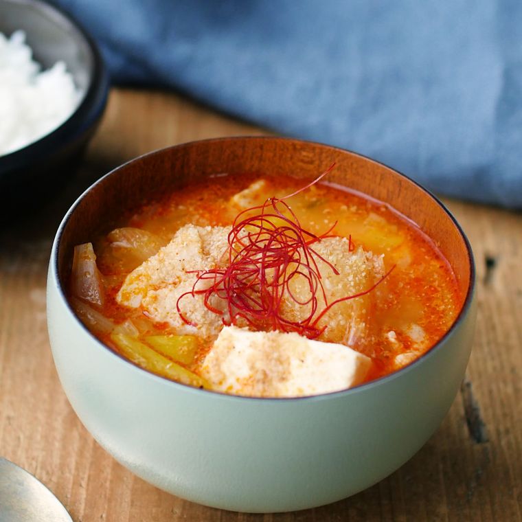 グレーの汁椀に盛り付けた玉ねぎと豆腐のピリ辛味噌汁