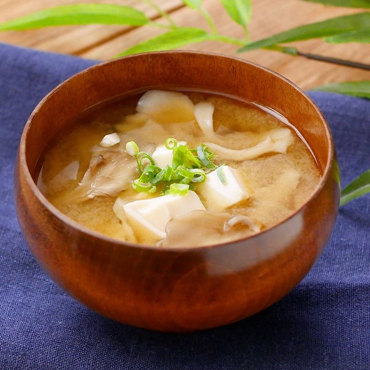 木製の汁椀に盛り付けたまいたけと豆腐の味噌汁