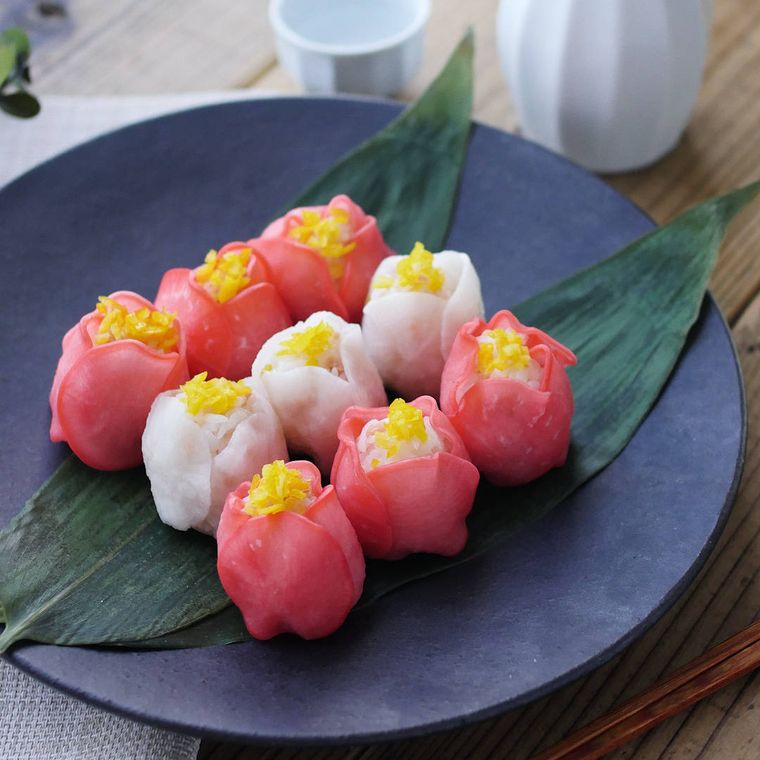 黒い皿に盛られた、大根の鮭フレーク入り椿手まり寿司