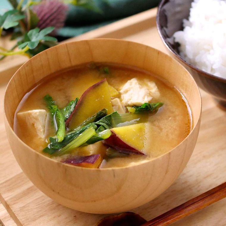 木製の汁椀に入れられたさつまいもと豆腐のみそ汁