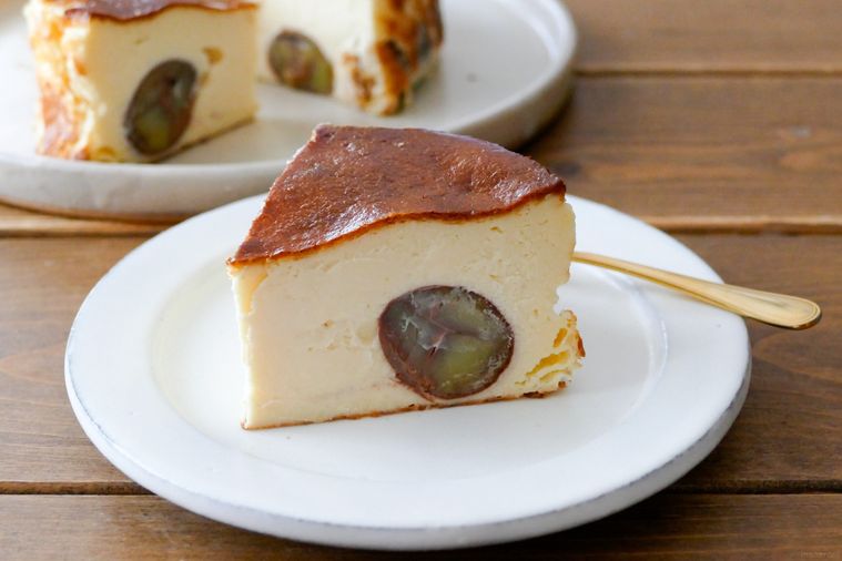 カットした栗のチーズケーキをのせた白い皿