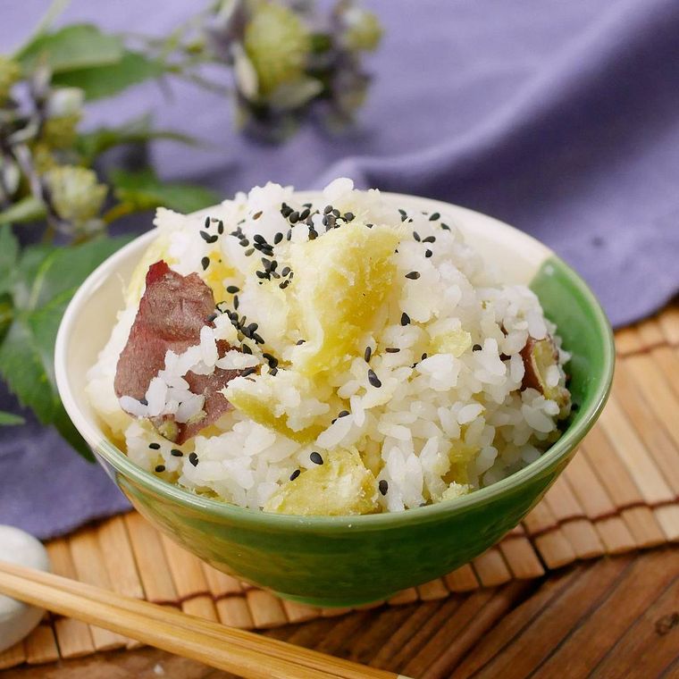 お茶碗にごま塩が振られたさつまいもの炊き込みごはんが盛られている