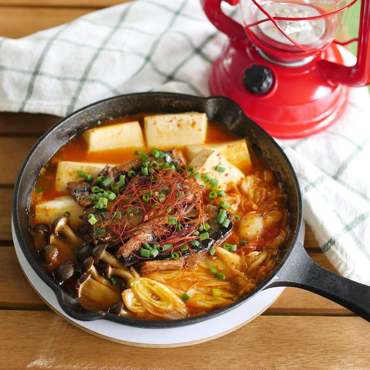絹豆腐たっぷりのさんま缶チゲが盛られたスキレットと赤いランタン