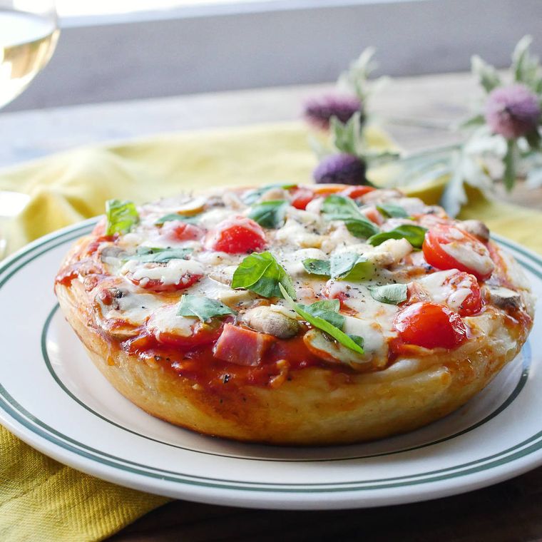 スキレットで焼いたシカゴピザを白いプレートに盛り付けている