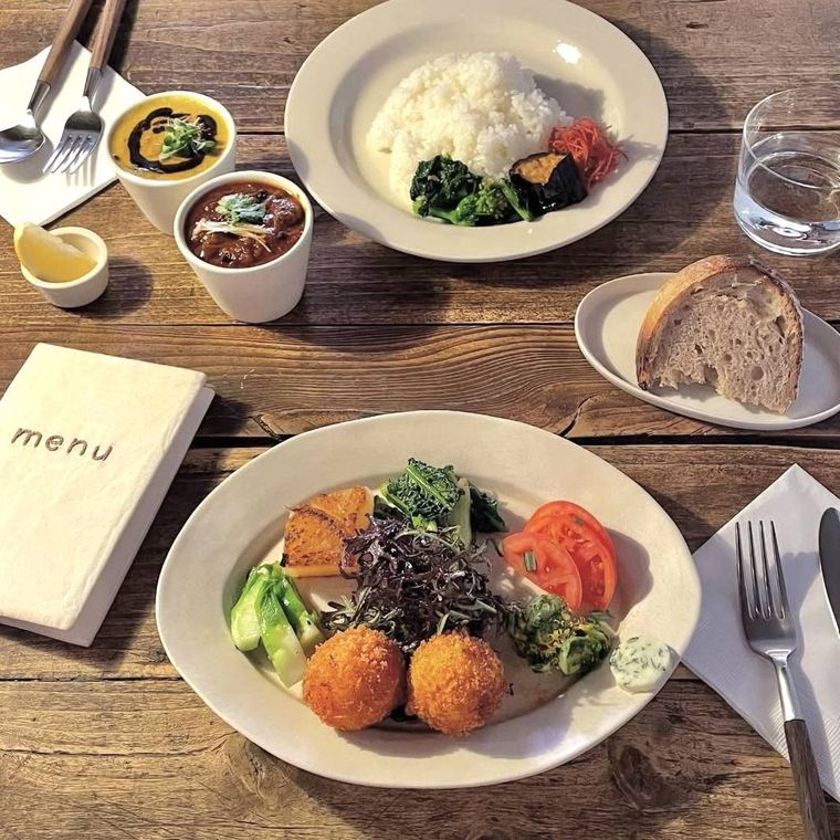 白い器に盛られた野菜とコロッケとご飯とパン、スープ