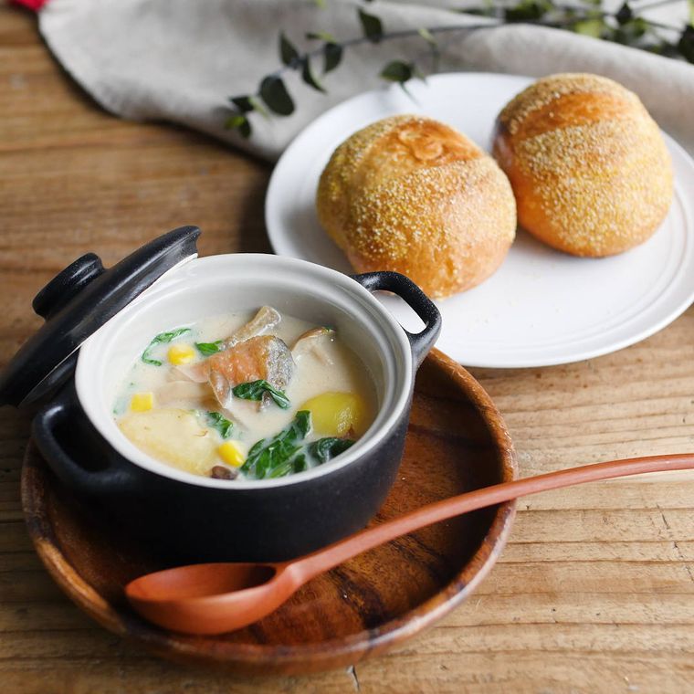 蓋付きの小鍋に盛りつけられた生鮭とほうれん草のミルクスープ