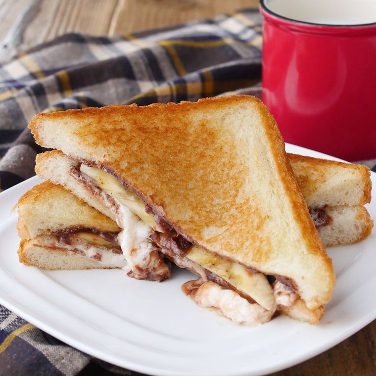 白いプレートに盛りつけられたチョコバナナホットサンドと赤いマグカップ