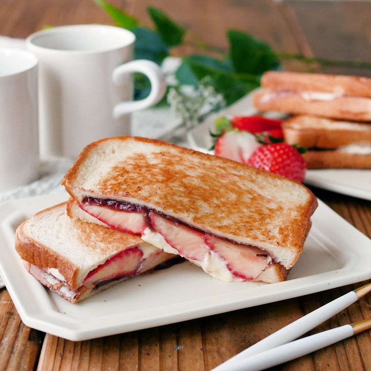 白いプレートに盛りつけられたいちご大福風ホットサンドに白いカップが添えられている