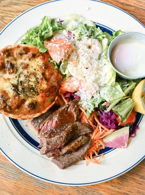 白いプレートに盛られた海老とサーモンのサラダラザニア牛ハラミステーキ トリプルメインランチ