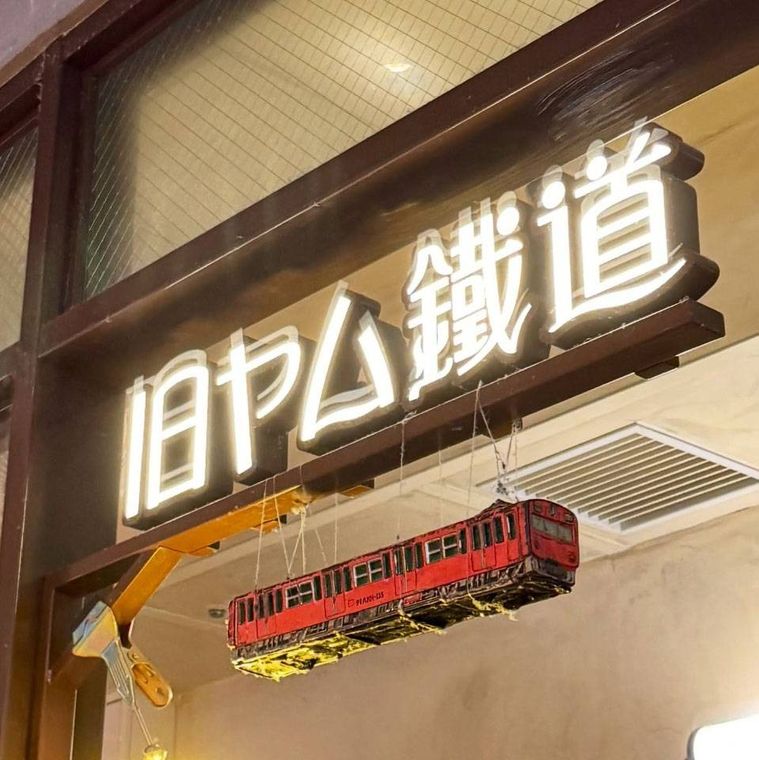 列車の模型が吊り下げられた旧ヤム鐡道の看板
