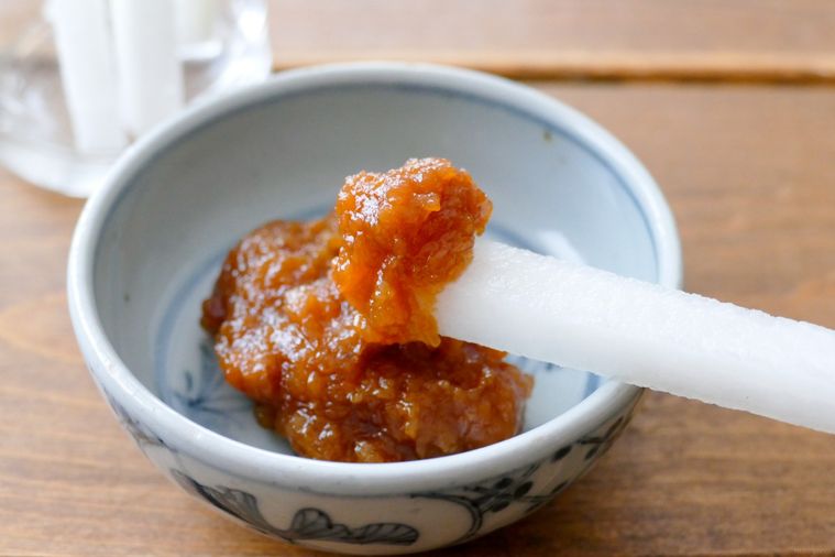 スティック状に切った大根に油みそをつける様子