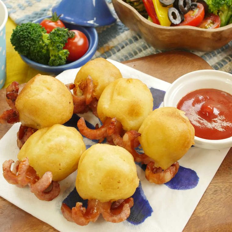 青い模様入りの白い皿に並んでいるマッシュポテトのたこソーセージ