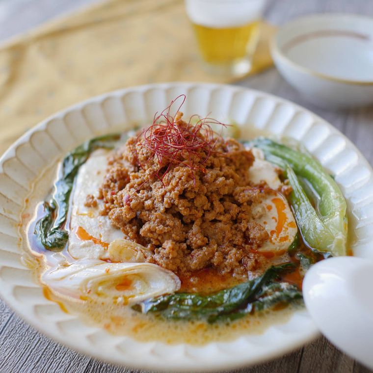白い皿に盛りつけられた肉そぼろとチンゲン菜入りの担々風湯豆腐