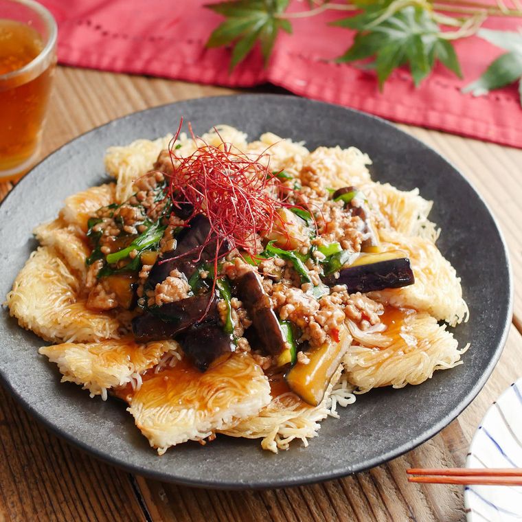 黒い丸皿に盛られた香ばしいあんかけそうめん