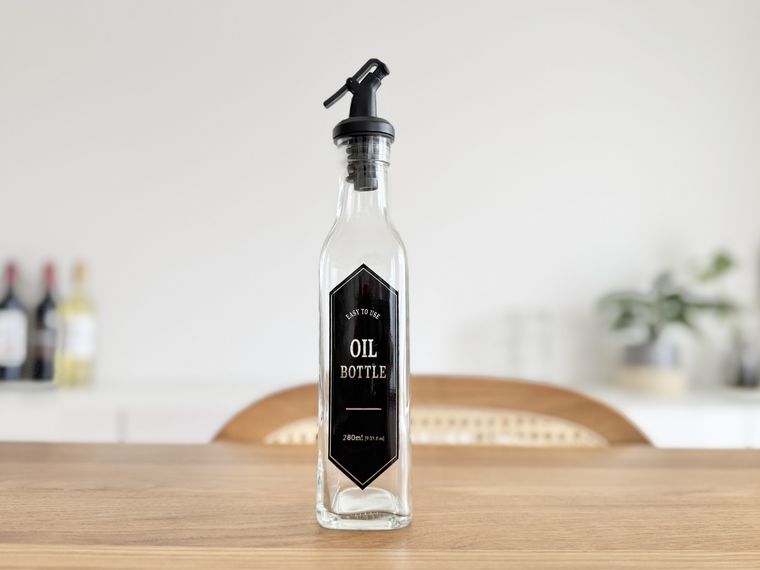 テーブルに置かれたダイソーガラスオイルボトルデザイン付、約280mL