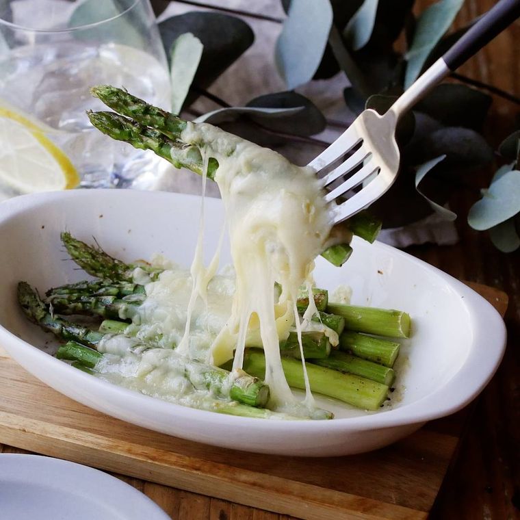 白い皿に盛り付けたアスパラのチーズ焼き