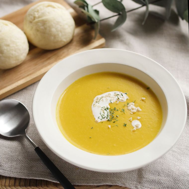 白い皿に盛りつけられたかぼちゃとセロリ、玉ねぎの冷製豆乳スープ