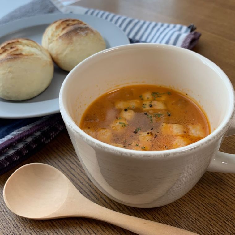白いスープカップに盛り付けたセロリとトマトのコンソメスープ