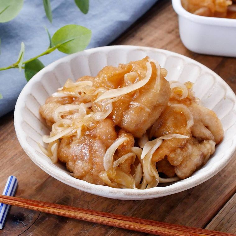 新玉ねぎたっぷりの鶏もも肉の南蛮漬けが皿に盛り付けられているところ
