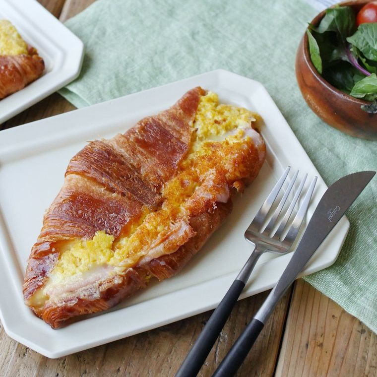 白い皿にのったハムチーズクロワッサンホットサンド