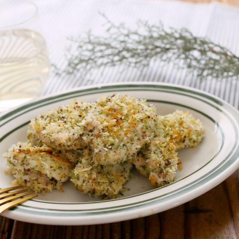 ライン入りの楕円系の皿に盛られた、鶏むね肉の香草パン粉焼き